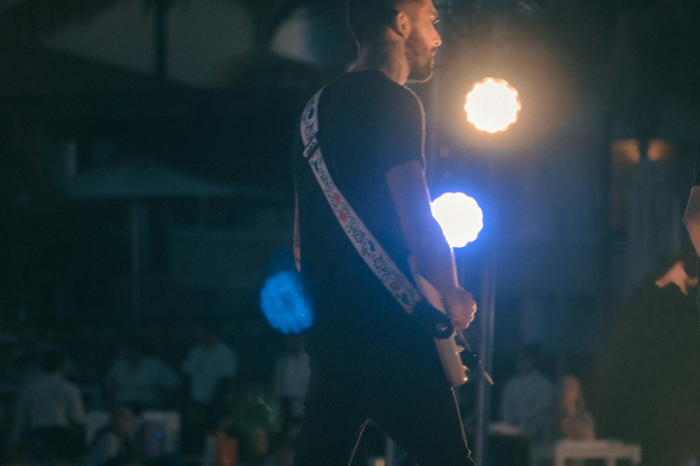 Chitarrista che suona la chitarra elettrica su un palco illuminato.
