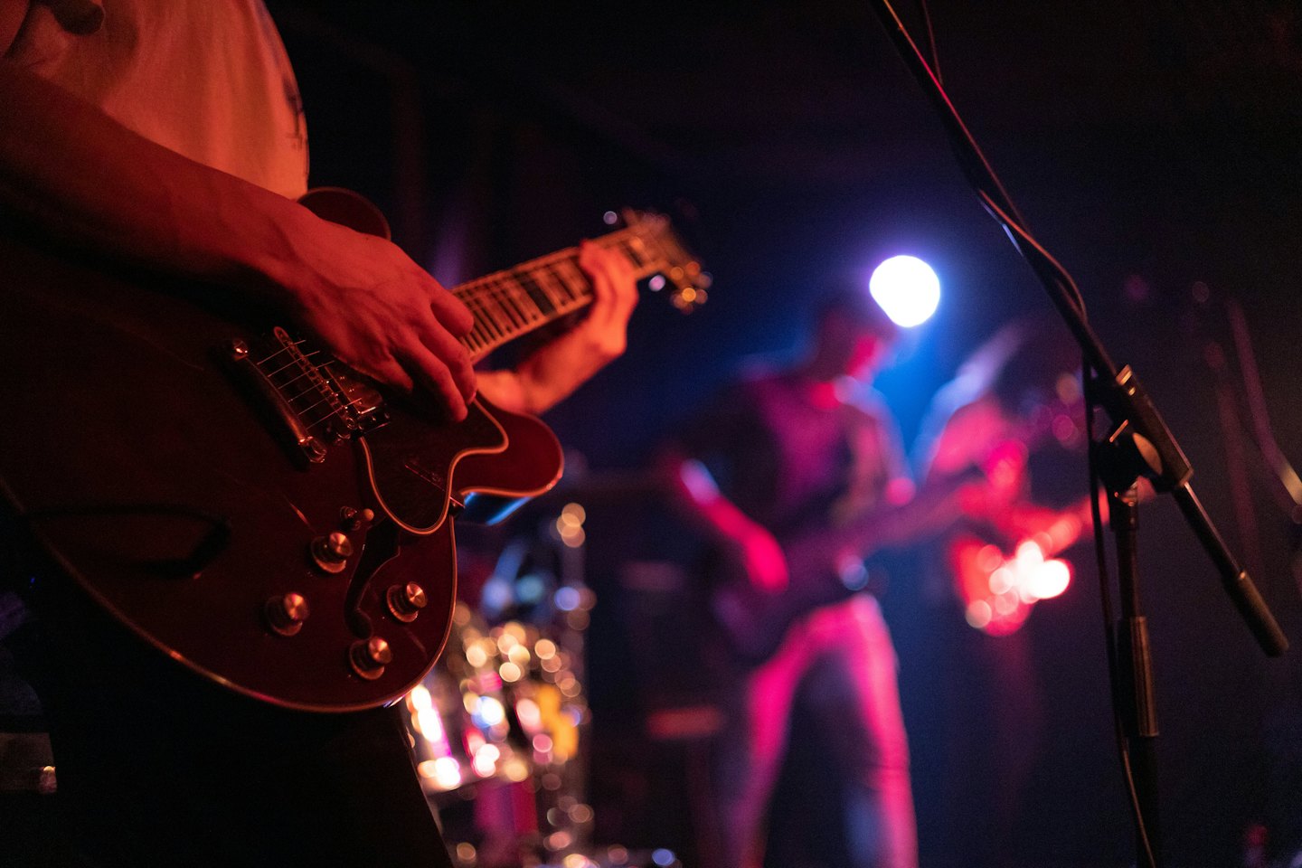 Musicista che suona una chitarra elettrica semi-hollow sul palco.